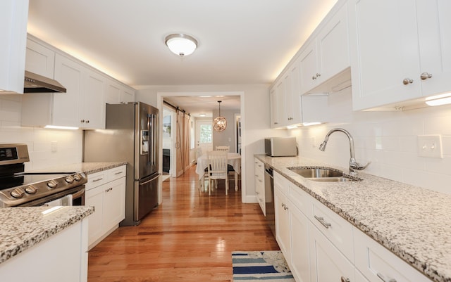 1 Ephraim Tyler Way Unit 1, Kennebunk, ME 04043 - kitchen with appliances with stainless steel finishes, white cabinetry, backsplash, and light wood finished floors