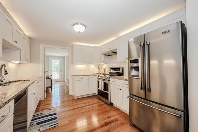 1 Ephraim Tyler Way Unit 1, Kennebunk, ME 04043 - kitchen with appliances with stainless steel finishes, white cabinets, light wood-type flooring, and backsplash