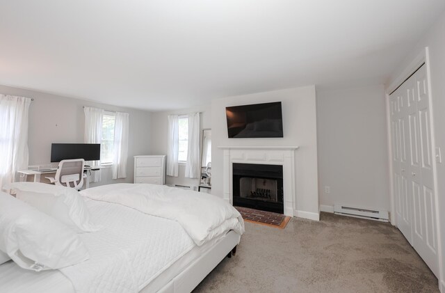 1 Ephraim Tyler Way Unit 1, Kennebunk, ME 04043 - bedroom with a baseboard radiator, a fireplace, carpet floors, a closet, and baseboard heating