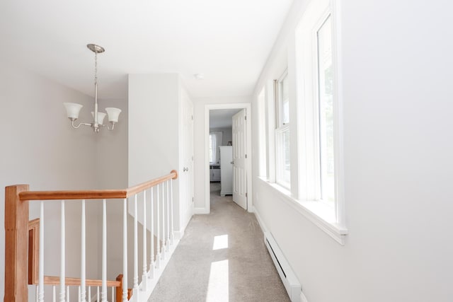 1 Ephraim Tyler Way Unit 1, Kennebunk, ME 04043 - corridor with baseboard heating, an upstairs landing, light carpet, and a chandelier