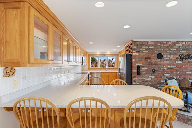 511 Webhannet Dr, Wells, ME 04090 - kitchen with stainless steel appliances, light countertops, backsplash, glass insert cabinets, and a peninsula