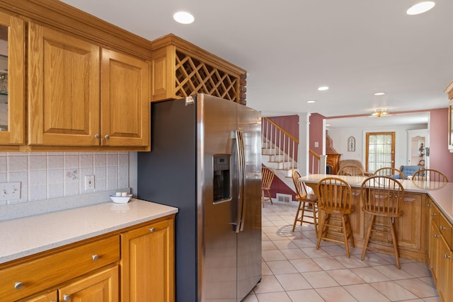 511 Webhannet Dr, Wells, ME 04090 - kitchen with stainless steel refrigerator with ice dispenser, decorative columns, light tile patterned floors, brown cabinets, and recessed lighting