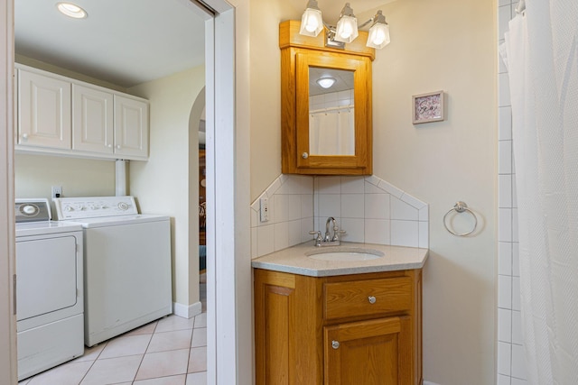 511 Webhannet Dr, Wells, ME 04090 - laundry room with washing machine and dryer, arched walkways, and light tile patterned floors