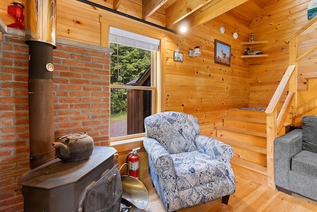 660 Sprague Rd, Waldoboro, ME 04572 - living area with a wood stove, wood finished floors, wooden walls, stairs, and beamed ceiling