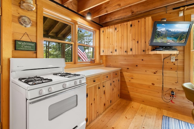 660 Sprague Rd, Waldoboro, ME 04572 - kitchen featuring white range with gas cooktop, wooden walls, light wood-type flooring, and light countertops