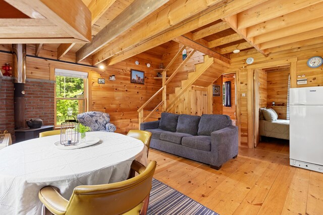 660 Sprague Rd, Waldoboro, ME 04572 - dining room with wooden walls, light wood-style flooring, stairs, and a wooden ceiling with exposed beams