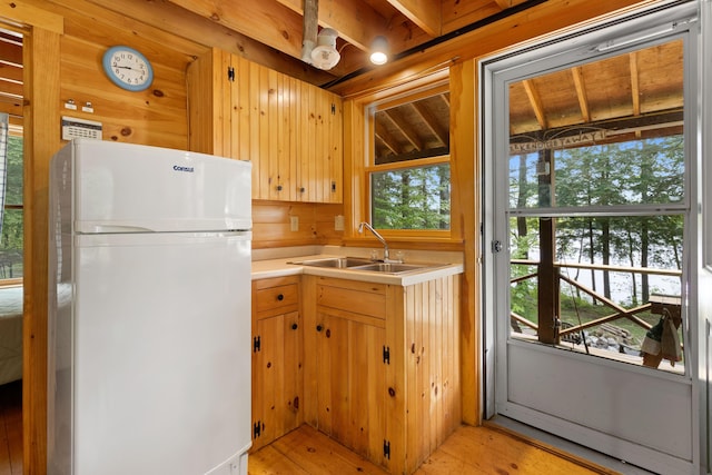 660 Sprague Rd, Waldoboro, ME 04572 - kitchen featuring freestanding refrigerator, light countertops, light wood-type flooring, and wood walls