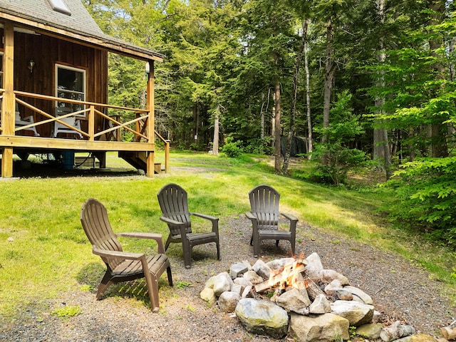 660 Sprague Rd, Waldoboro, ME 04572 - view of grassy yard with a fire pit, a wooden deck, and a forest view