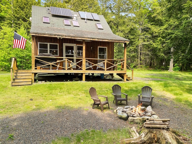 660 Sprague Rd, Waldoboro, ME 04572 - back of house featuring a fire pit, a lawn, solar panels, and a shingled roof