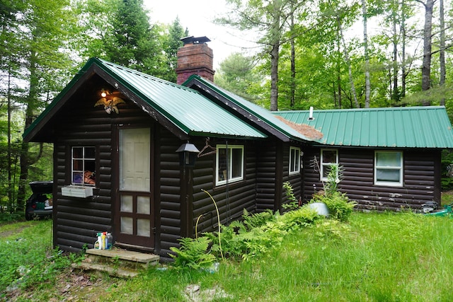 866 School St, Perkins Twp, ME 04294 - back of house with a chimney, faux log siding, and a metal roof