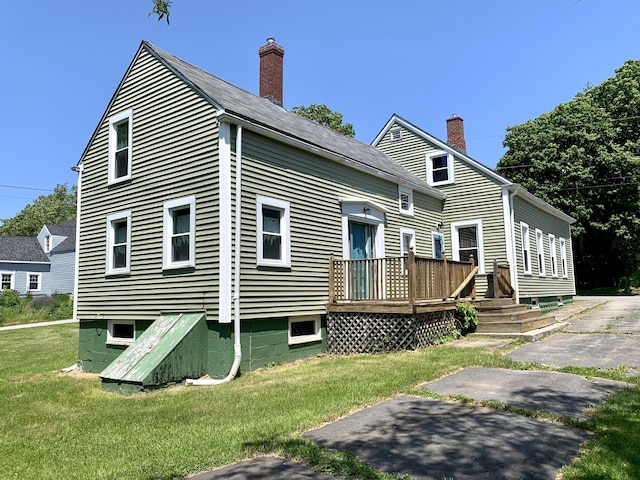 14 Third St, Eastport, ME 04631 - rear view of house featuring a deck, a lawn, and a chimney