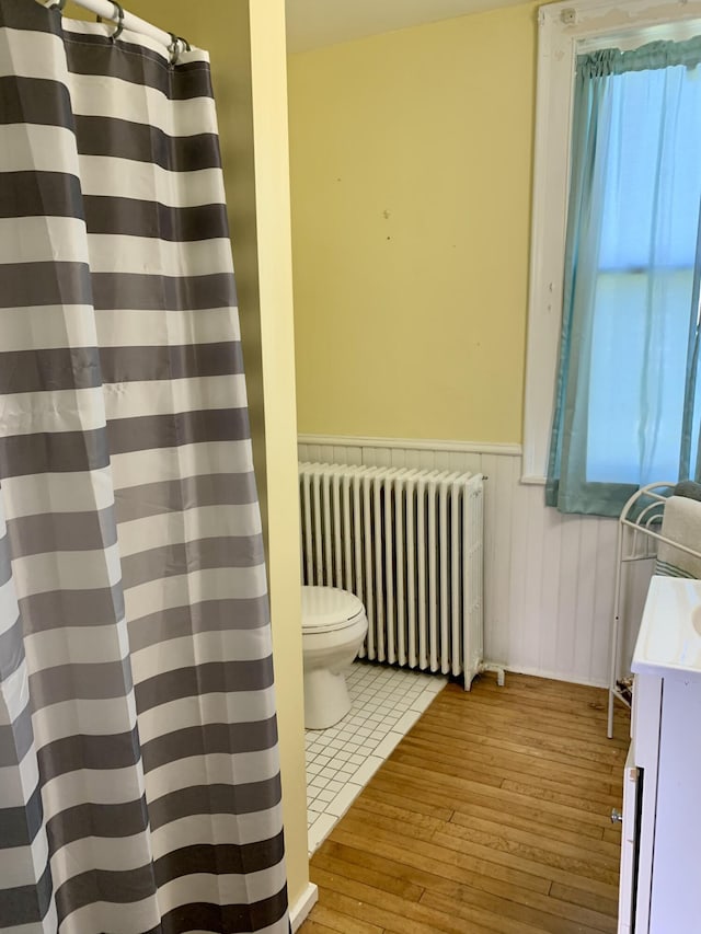 14 Third St, Eastport, ME 04631 - bathroom with radiator, hardwood / wood-style floors, wainscoting, vanity, and a shower with curtain
