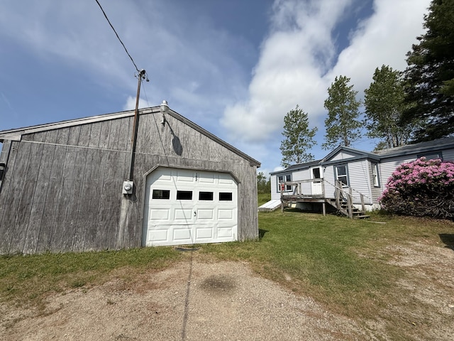 152 Kansas Rd, Milbridge, ME 04658 - view of home's exterior with driveway, a detached garage, and a lawn