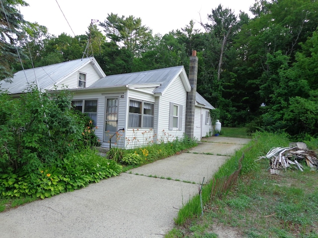 59 Main St, Shapleigh, ME 04076 - view of side of home featuring a chimney and a metal roof