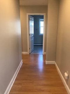 406 Cumberland St, Westbrook, ME 04092 - hallway with wood finished floors and a baseboard heating unit