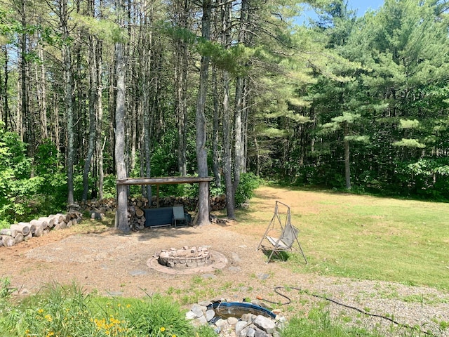 2857 Ohio St, Glenburn, ME 04401 - view of grassy yard with an outdoor fire pit and a forest view