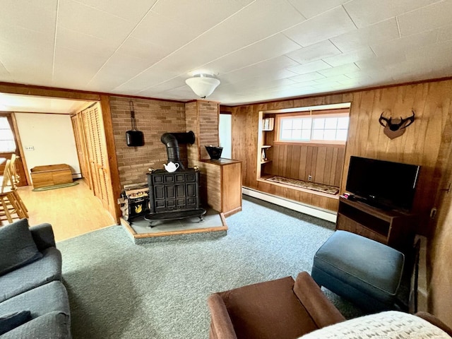 41 York St, Millinocket, ME 04462 - living room with baseboard heating, a wood stove, wood walls, and carpet flooring