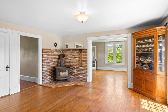 39 Elm St, South Thomaston, ME 04858 - unfurnished living room with light wood-style flooring and a wood stove