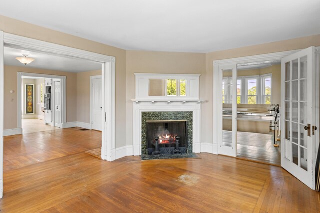39 Elm St, South Thomaston, ME 04858 - unfurnished living room featuring french doors, hardwood / wood-style flooring, and a premium fireplace
