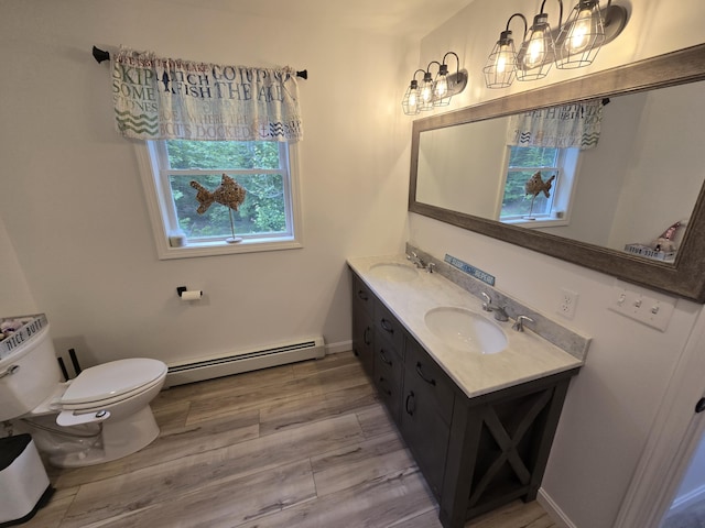 1083 N Rd, Newburgh, ME 04444 - bathroom featuring a baseboard radiator, double vanity, and wood finished floors