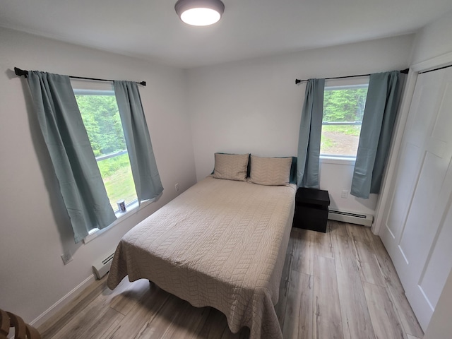 1083 N Rd, Newburgh, ME 04444 - bedroom featuring a baseboard heating unit and light wood-style flooring