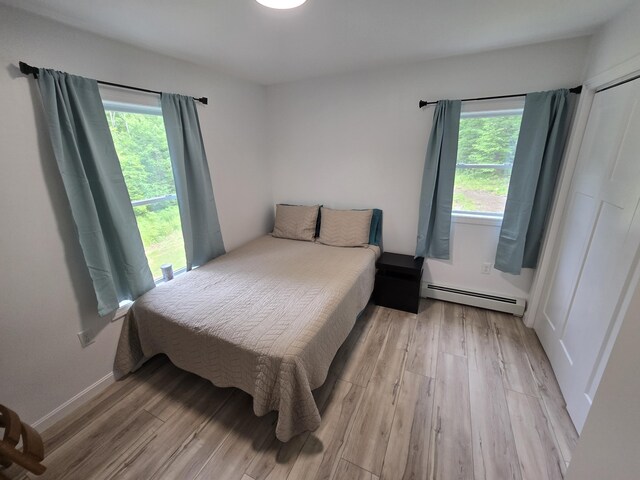 1083 N Rd, Newburgh, ME 04444 - bedroom with a baseboard heating unit and light wood-style flooring