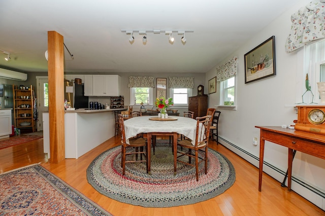 365 Waterville Rd, Skowhegan, ME 04976 - dining room featuring rail lighting, a baseboard heating unit, an AC wall unit, and light wood-style flooring