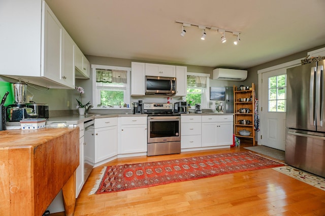 365 Waterville Rd, Skowhegan, ME 04976 - kitchen featuring stainless steel appliances, light wood-type flooring, plenty of natural light, and white cabinets