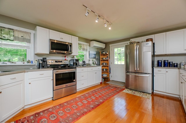 365 Waterville Rd, Skowhegan, ME 04976 - kitchen featuring stainless steel appliances, a wall mounted AC, and light wood-style flooring