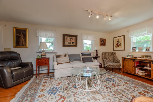 365 Waterville Rd, Skowhegan, ME 04976 - living area featuring a baseboard heating unit, healthy amount of natural light, track lighting, and wood finished floors