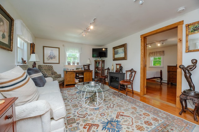 365 Waterville Rd, Skowhegan, ME 04976 - living area with track lighting, healthy amount of natural light, wood finished floors, and a baseboard radiator