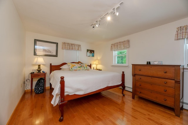 365 Waterville Rd, Skowhegan, ME 04976 - bedroom with rail lighting, light wood-style floors, and a baseboard heating unit