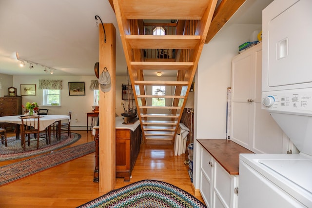 365 Waterville Rd, Skowhegan, ME 04976 - stairway with stacked washer / dryer, wood finished floors, rail lighting, and a baseboard radiator