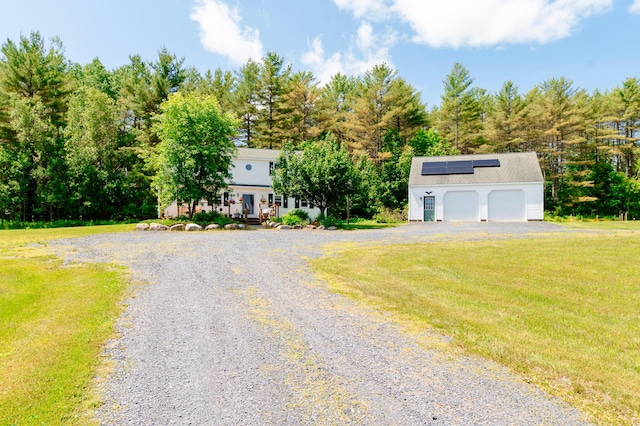 365 Waterville Rd, Skowhegan, ME 04976 - view of front of house with roof mounted solar panels, a front yard, view of scattered trees, and a detached garage