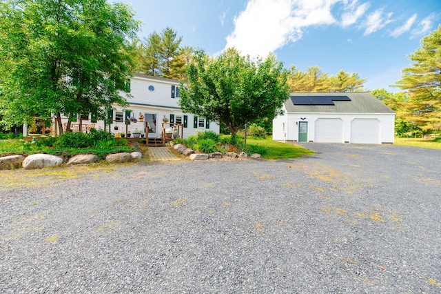 365 Waterville Rd, Skowhegan, ME 04976 - view of front facade with roof mounted solar panels, a deck, and a detached garage