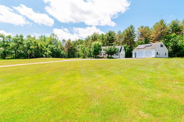 365 Waterville Rd, Skowhegan, ME 04976 - view of green lawn featuring a detached garage, an outdoor structure, and view of wooded area