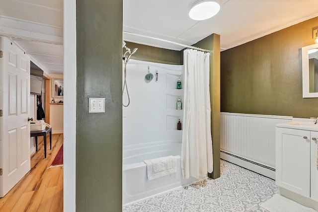 171 Bassett Rd, Winslow, ME 04901 - bathroom with a baseboard heating unit, vanity, shower / bath combo with shower curtain, wainscoting, and wood finished floors