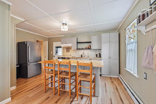 171 Bassett Rd, Winslow, ME 04901 - kitchen with freestanding refrigerator, open shelves, baseboard heating, wood counters, and light wood-style flooring