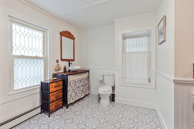 171 Bassett Rd, Winslow, ME 04901 - bathroom featuring baseboard heating, wainscoting, vanity, and crown molding