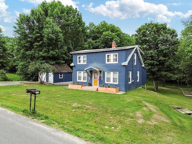 171 Bassett Rd, Winslow, ME 04901 - view of front of house with a front yard, a chimney, and an outbuilding