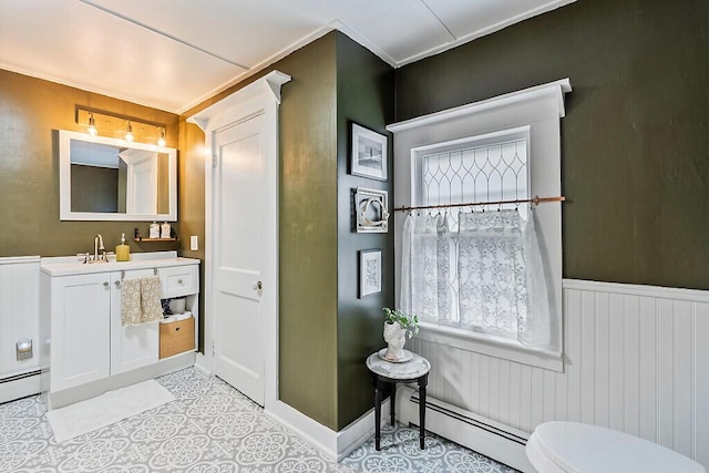171 Bassett Rd, Winslow, ME 04901 - half bath with a baseboard radiator, vanity, and a wainscoted wall