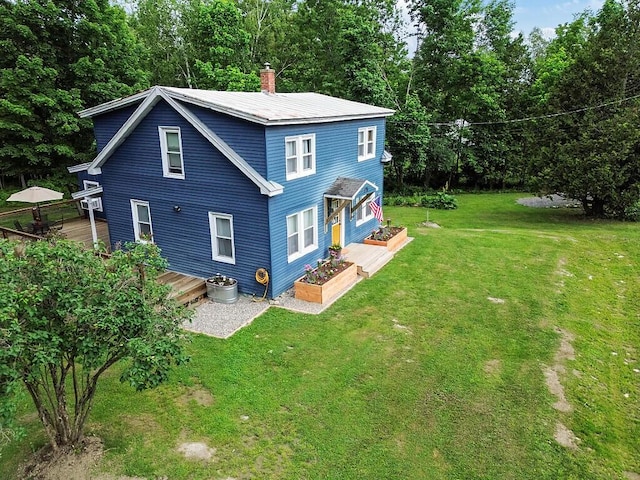 171 Bassett Rd, Winslow, ME 04901 - rear view of house featuring a deck, a lawn, view of scattered trees, and a chimney