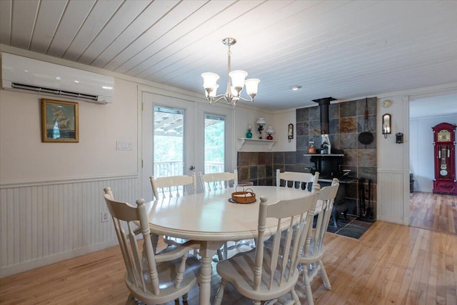 25 Pine View Ridge Rd, Boothbay, ME 04537 - dining area with an AC wall unit, light wood-style floors, a chandelier, a wood stove, and wooden ceiling