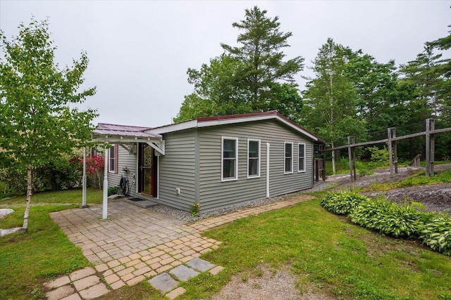 25 Pine View Ridge Rd, Boothbay, ME 04537 - view of front of property featuring a patio, a front lawn, and a metal roof