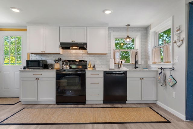 11 Farmhouse Way Unit 11, Ogunquit, ME 03907 - kitchen with black appliances, under cabinet range hood, decorative backsplash, white cabinetry, and light wood-style flooring