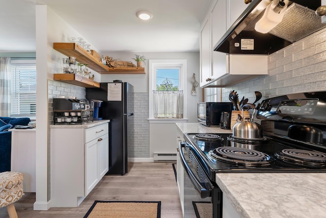 11 Farmhouse Way Unit 11, Ogunquit, ME 03907 - kitchen featuring exhaust hood, black appliances, baseboard heating, light countertops, and open shelves