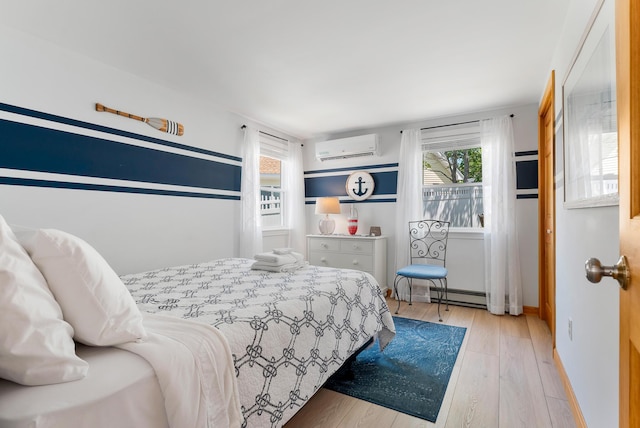 11 Farmhouse Way Unit 11, Ogunquit, ME 03907 - bedroom featuring an AC wall unit, multiple windows, light wood-style flooring, and a baseboard heating unit