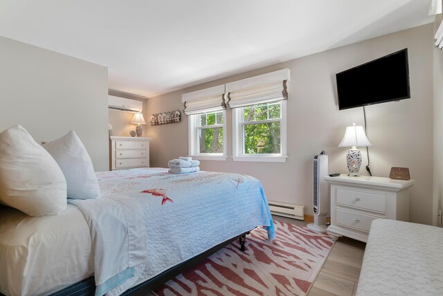 11 Farmhouse Way Unit 11, Ogunquit, ME 03907 - bedroom featuring a wall mounted air conditioner, a baseboard radiator, and wood finished floors
