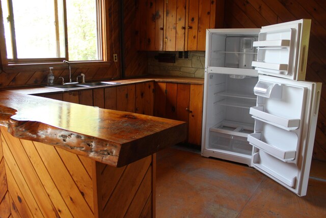 189 E Shore Rd, Benedicta Twp, ME 04733 - kitchen with refrigerator, brown cabinetry, a peninsula, and light countertops