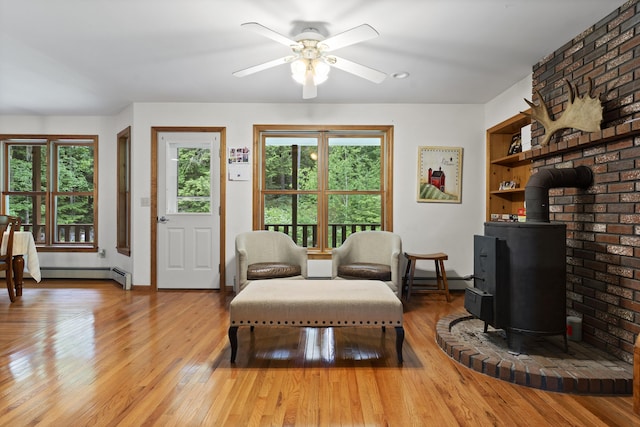 14 Moody Pond Rd, Windsor, ME 04363 - living room with a wood stove, plenty of natural light, light wood finished floors, and a ceiling fan